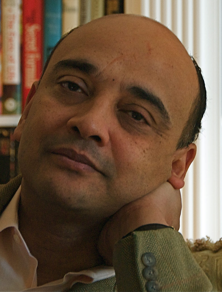 Headshot of Kwame Anthony Appiah in front of bookshelves