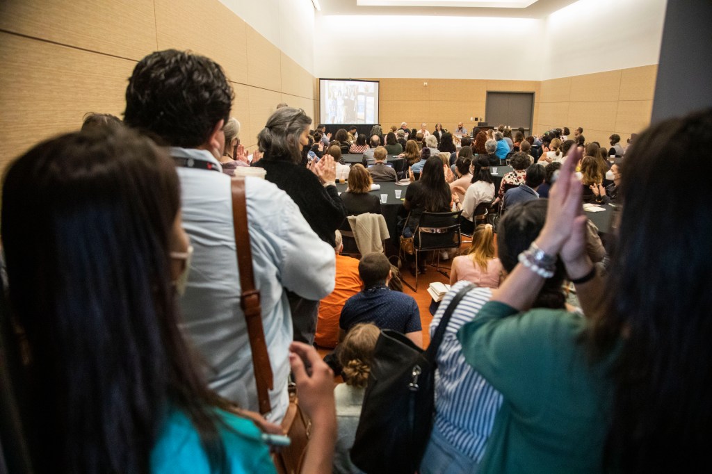 back of an audience clapping in a session room