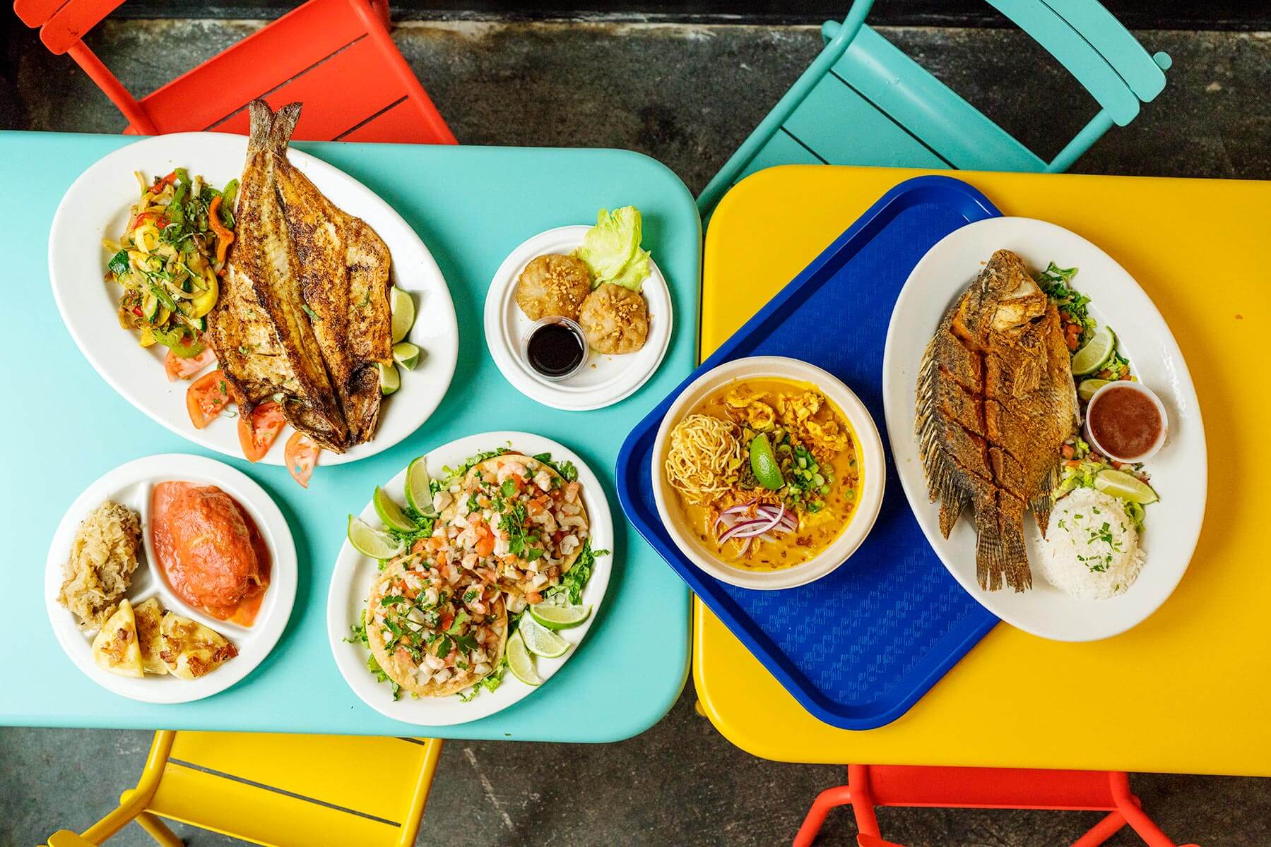 A colorful photo of plates of food including fried fish