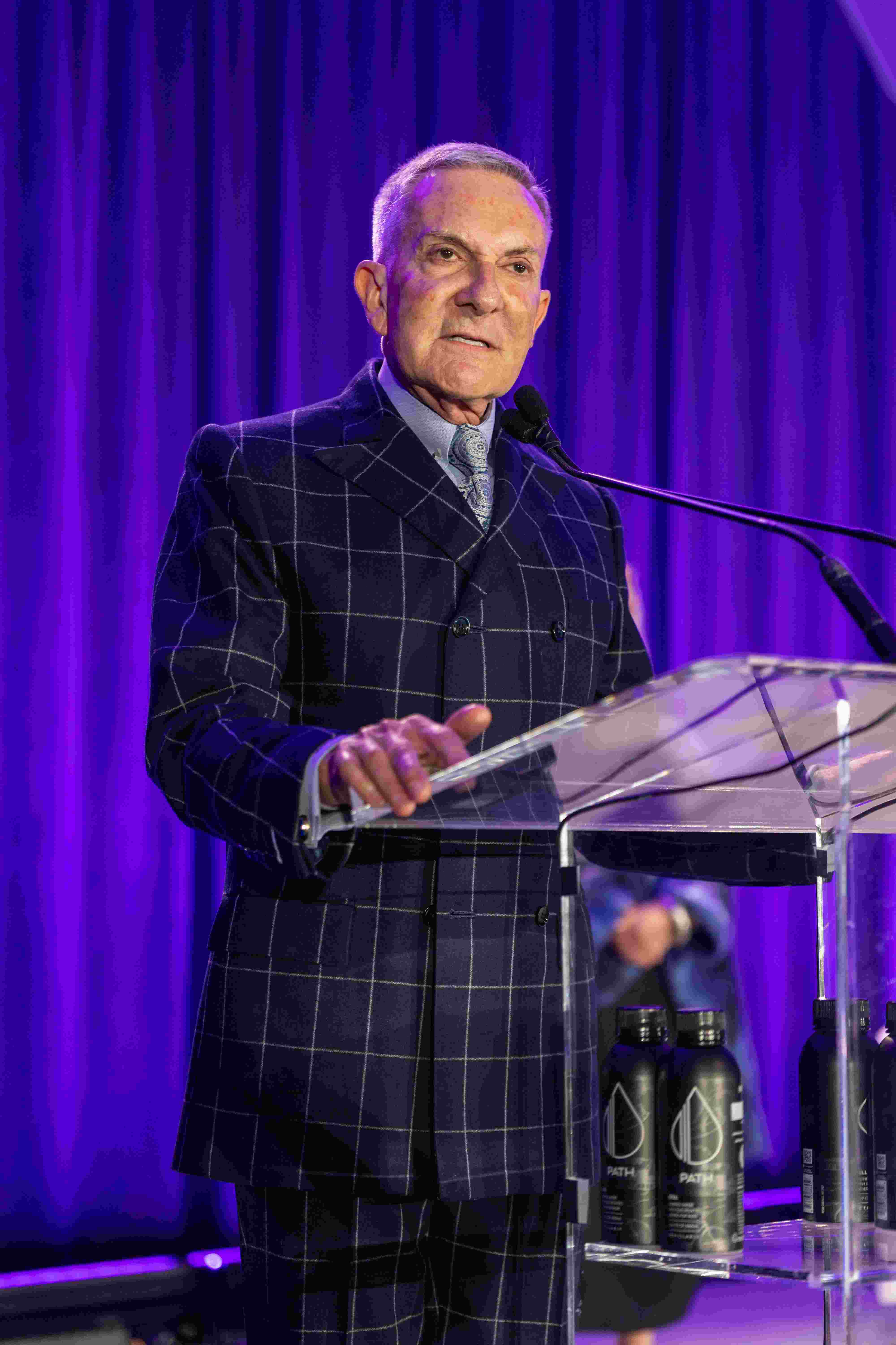 Richard West gives remarks on stage after receiving his award