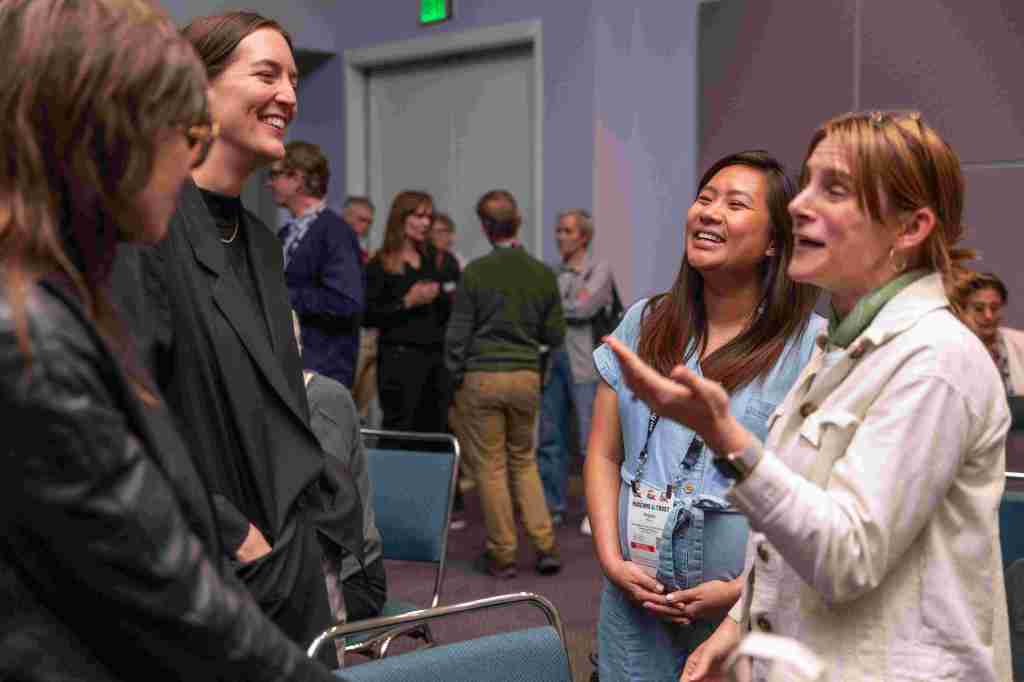 Four people in conversation and laughing
