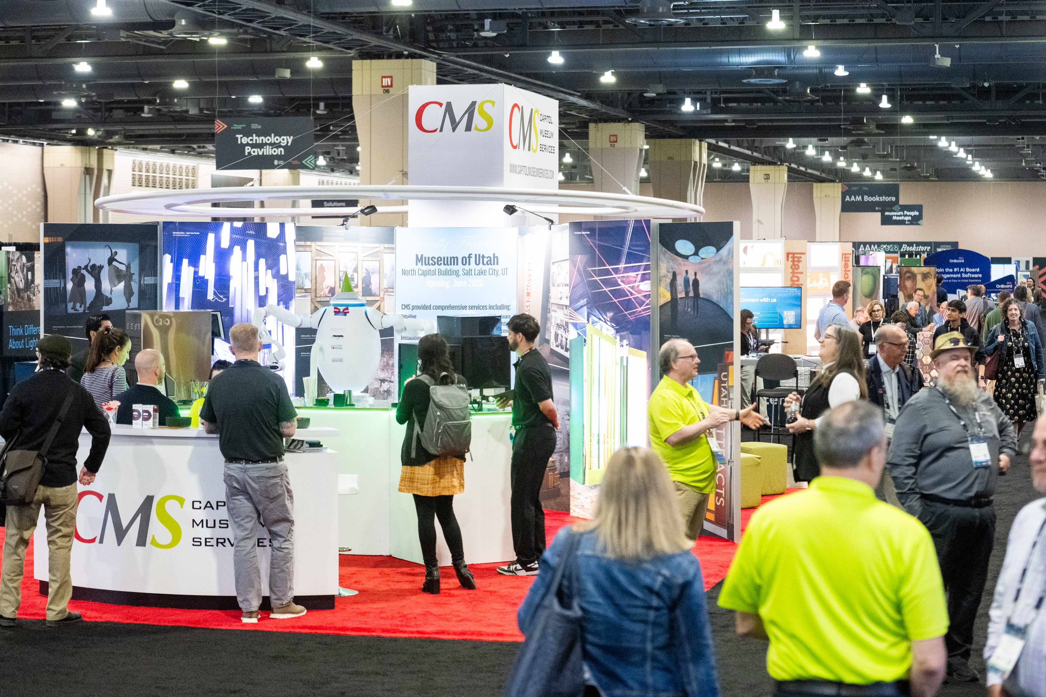 A busy museum expo hall in front of the CMS booth