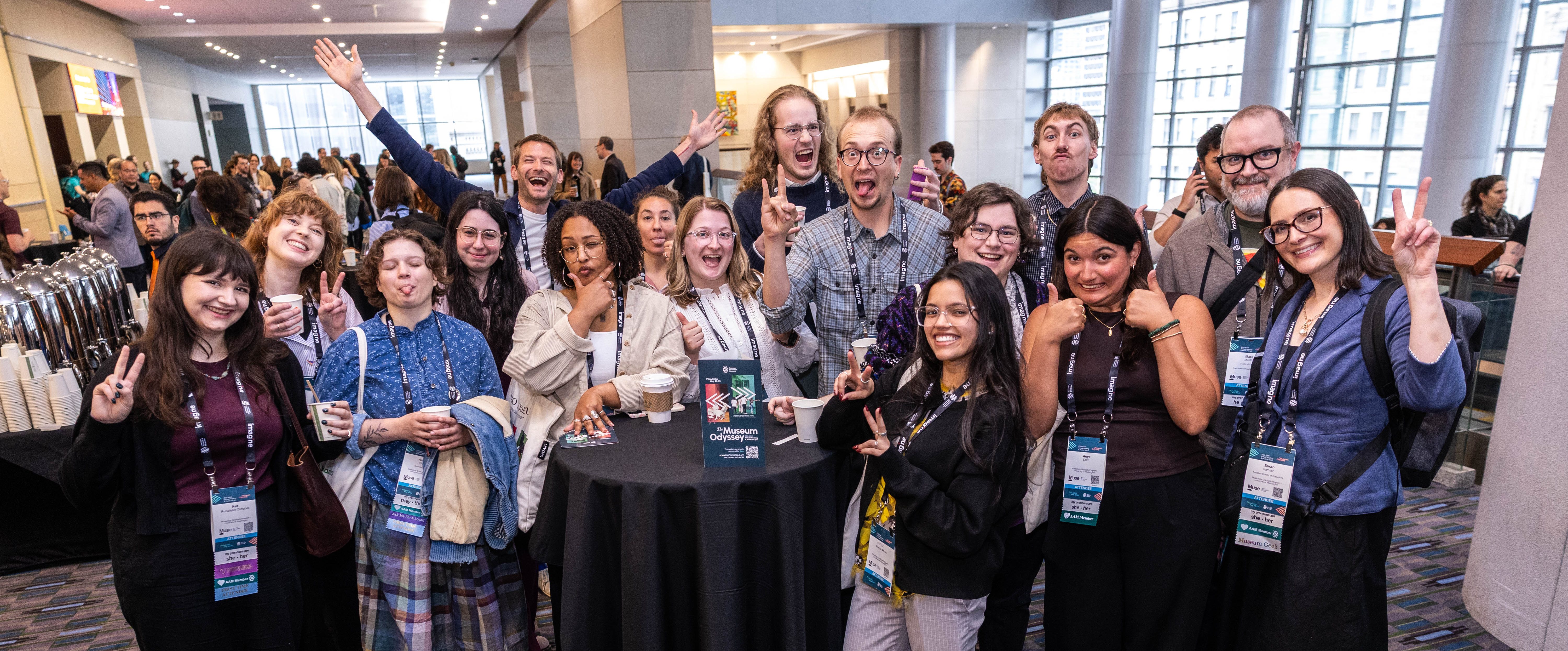 A group of attendees pose for a photo making silly faces and peace signs